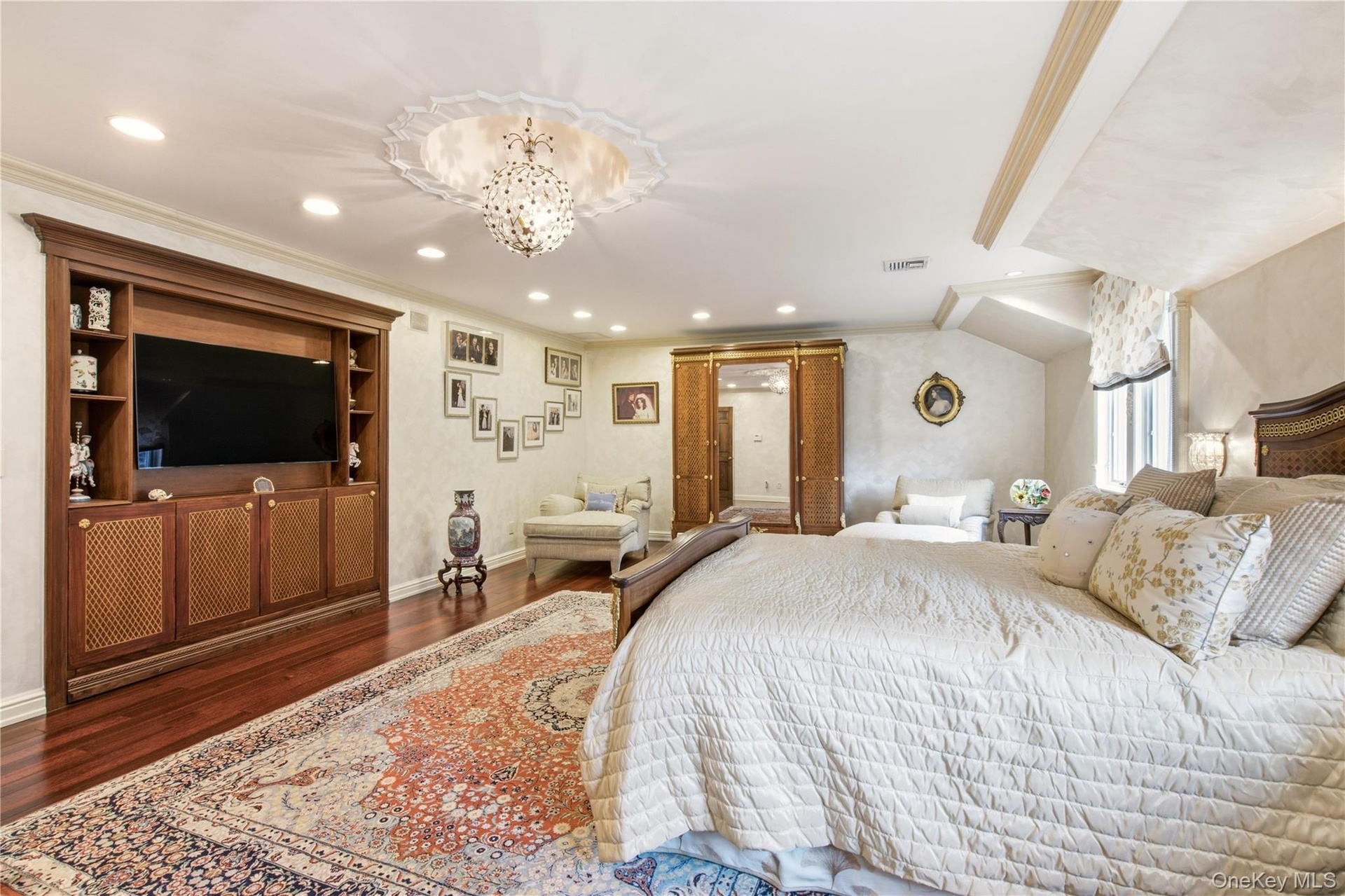 Recessed lighting illuminates wood-finish flooring and a built-in entertainment center