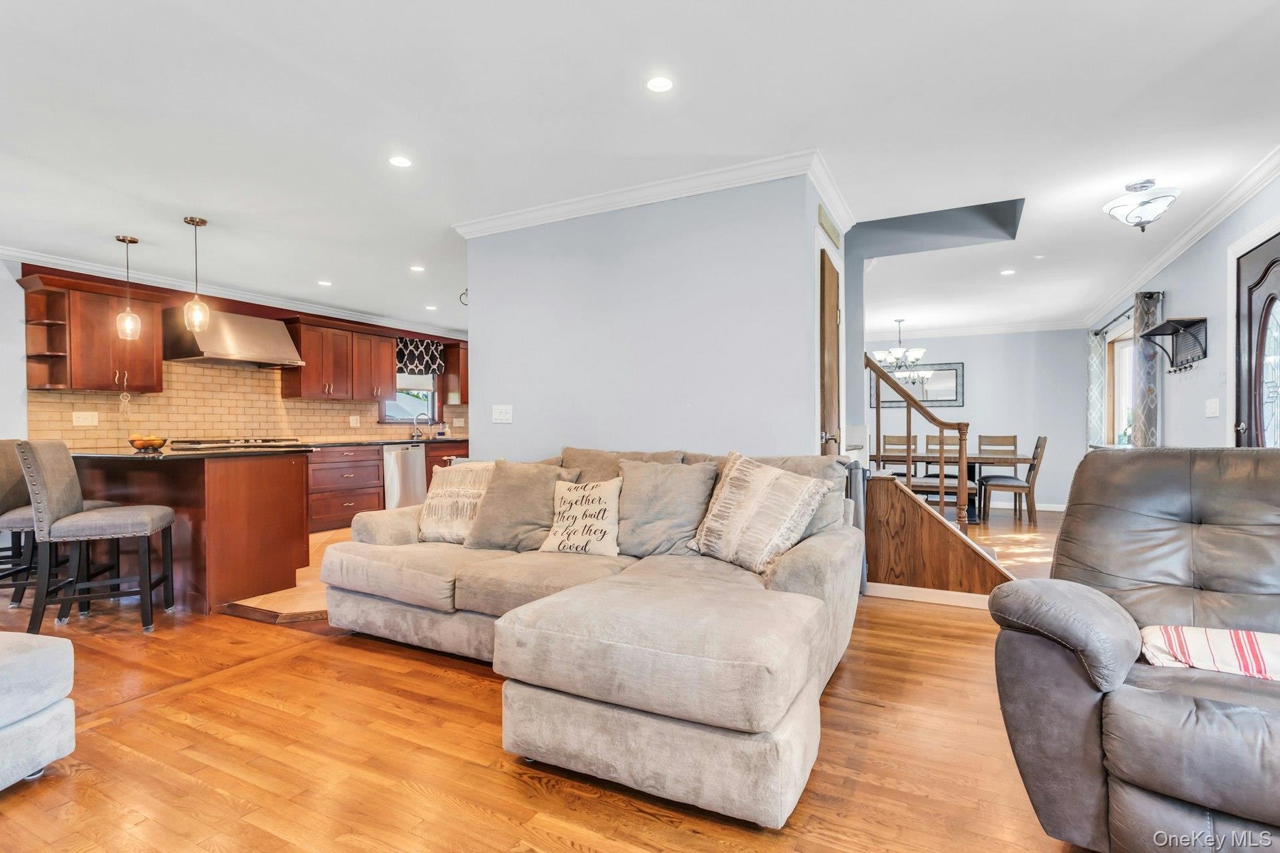 Hardwood flooring, recessed lighting, crown molding, stainless steel appliances, and a tiled kitchen backsplash