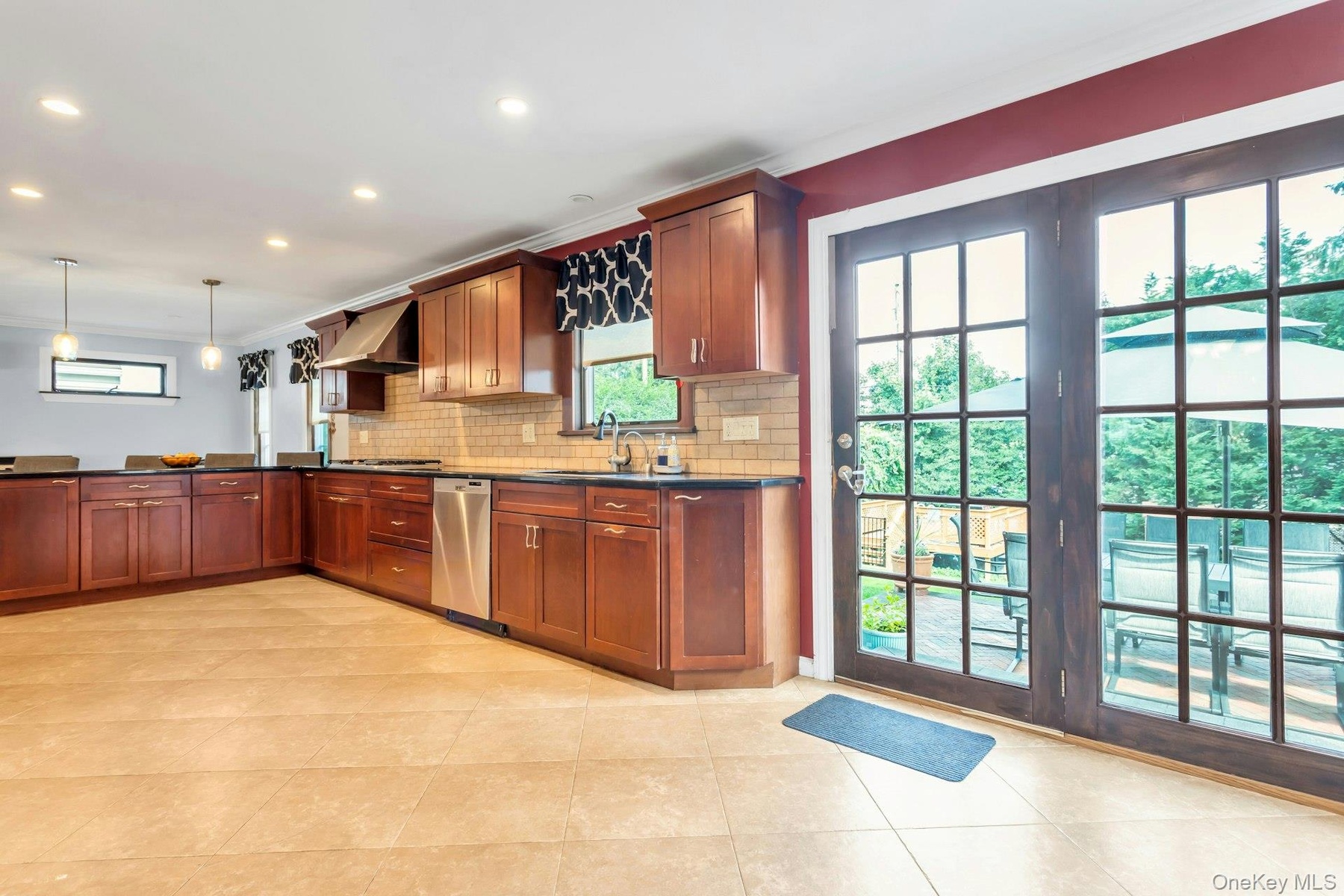 U-shaped kitchen featuring wood cabinetry, stainless steel appliances, dark countertops, a subway tile backsplash, and recessed lighting