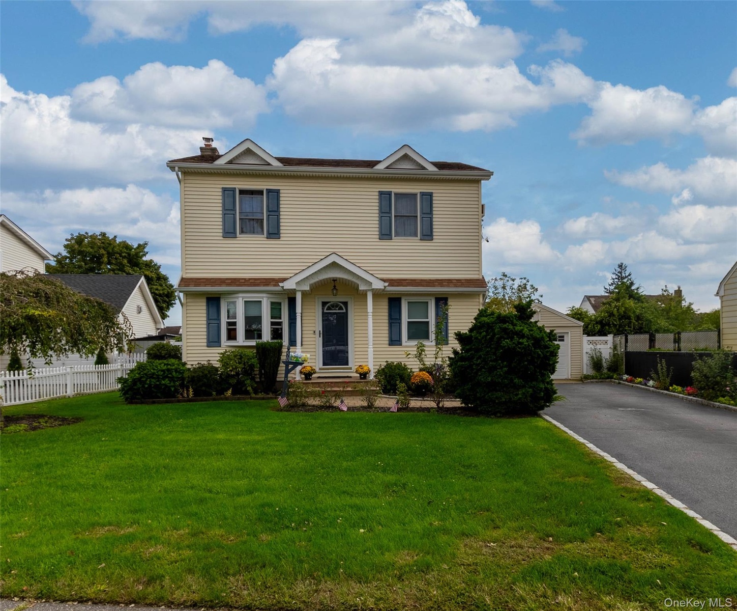 Two-story residence with light-colored siding, a covered entry, and bay window