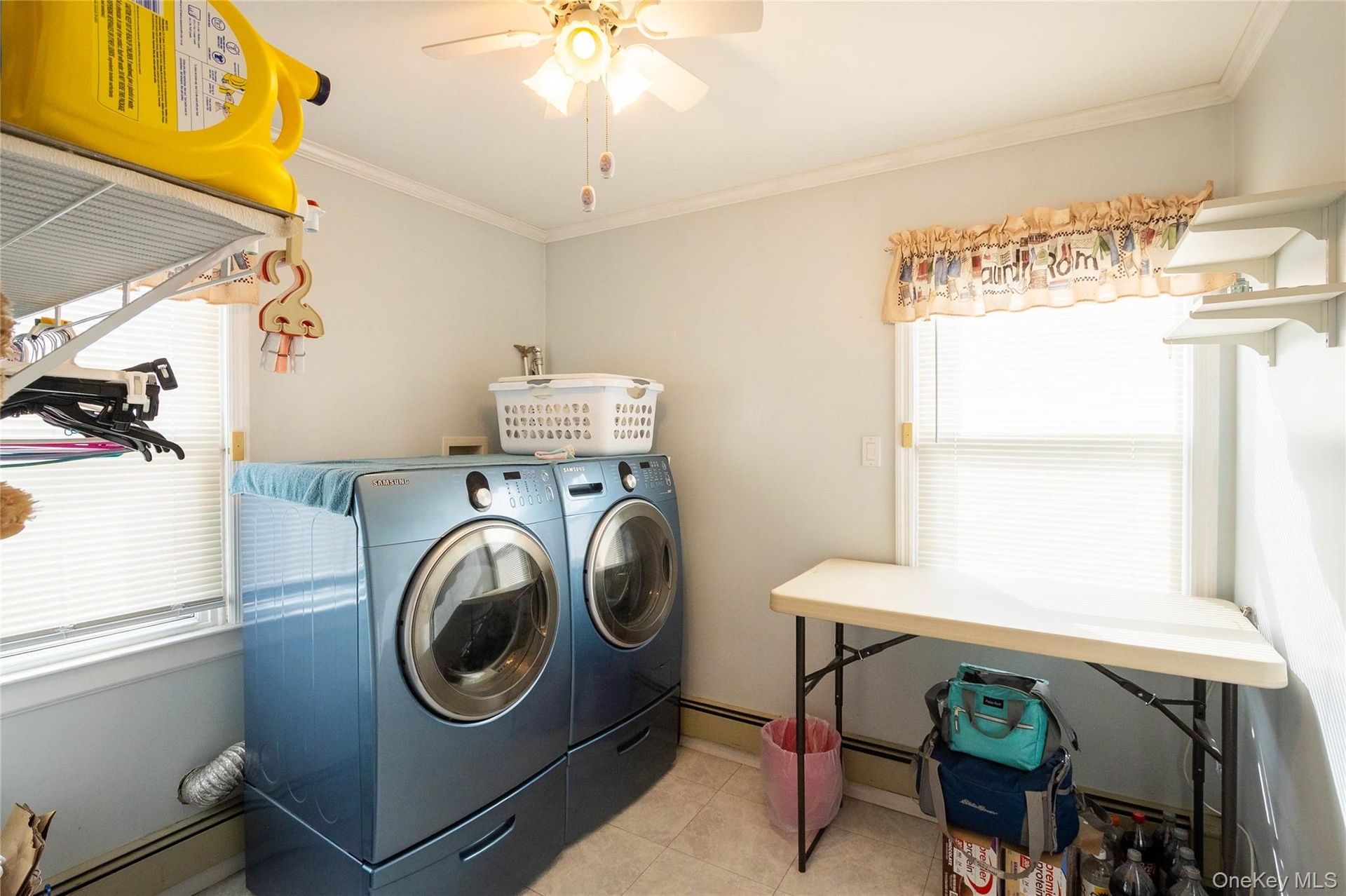 Laundry area featuring a ceiling fan, window with blinds, wall-mounted shelving, and tile flooring