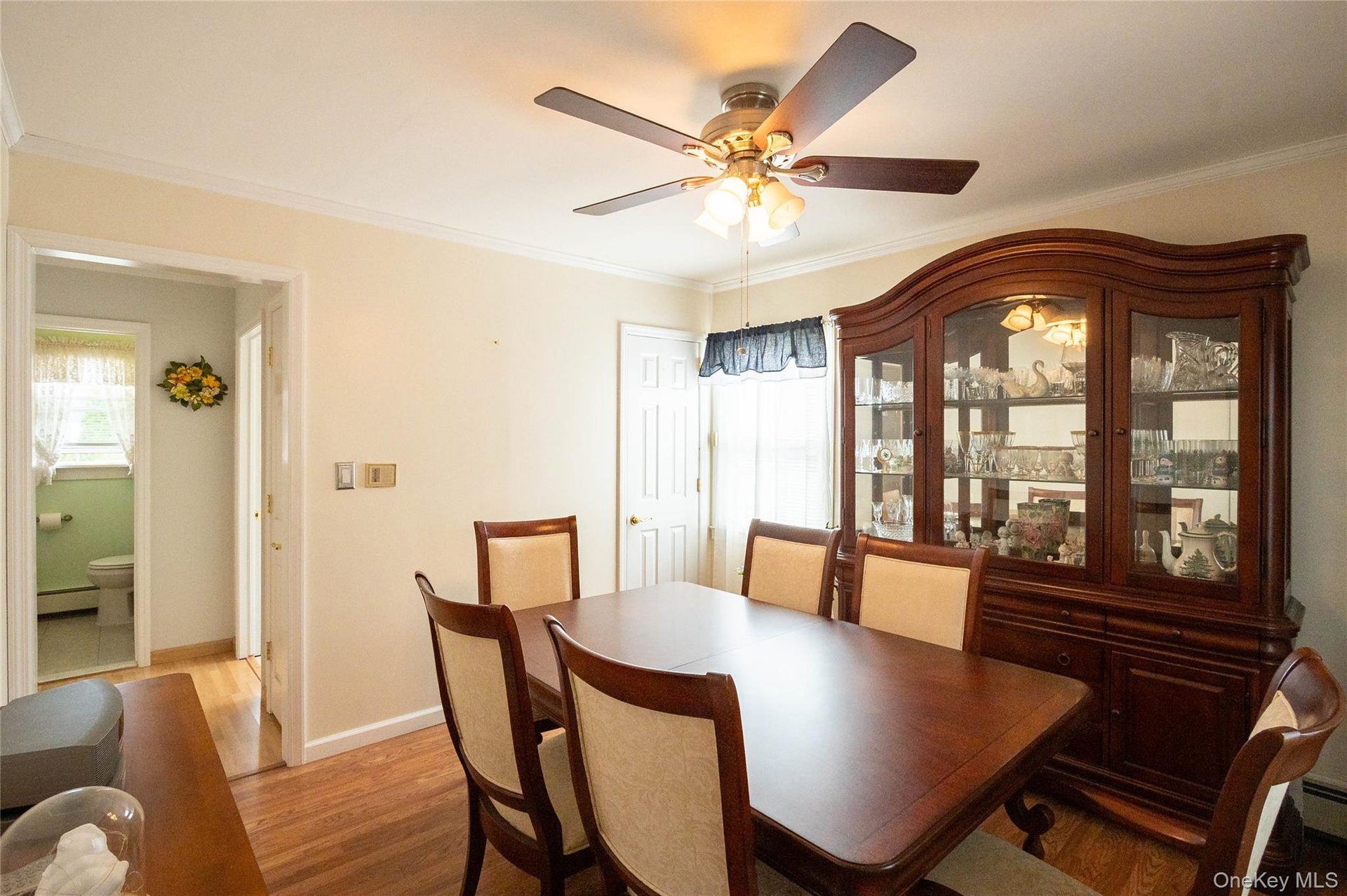 Hardwood flooring throughout, crown molding, and a ceiling fan with integrated lighting