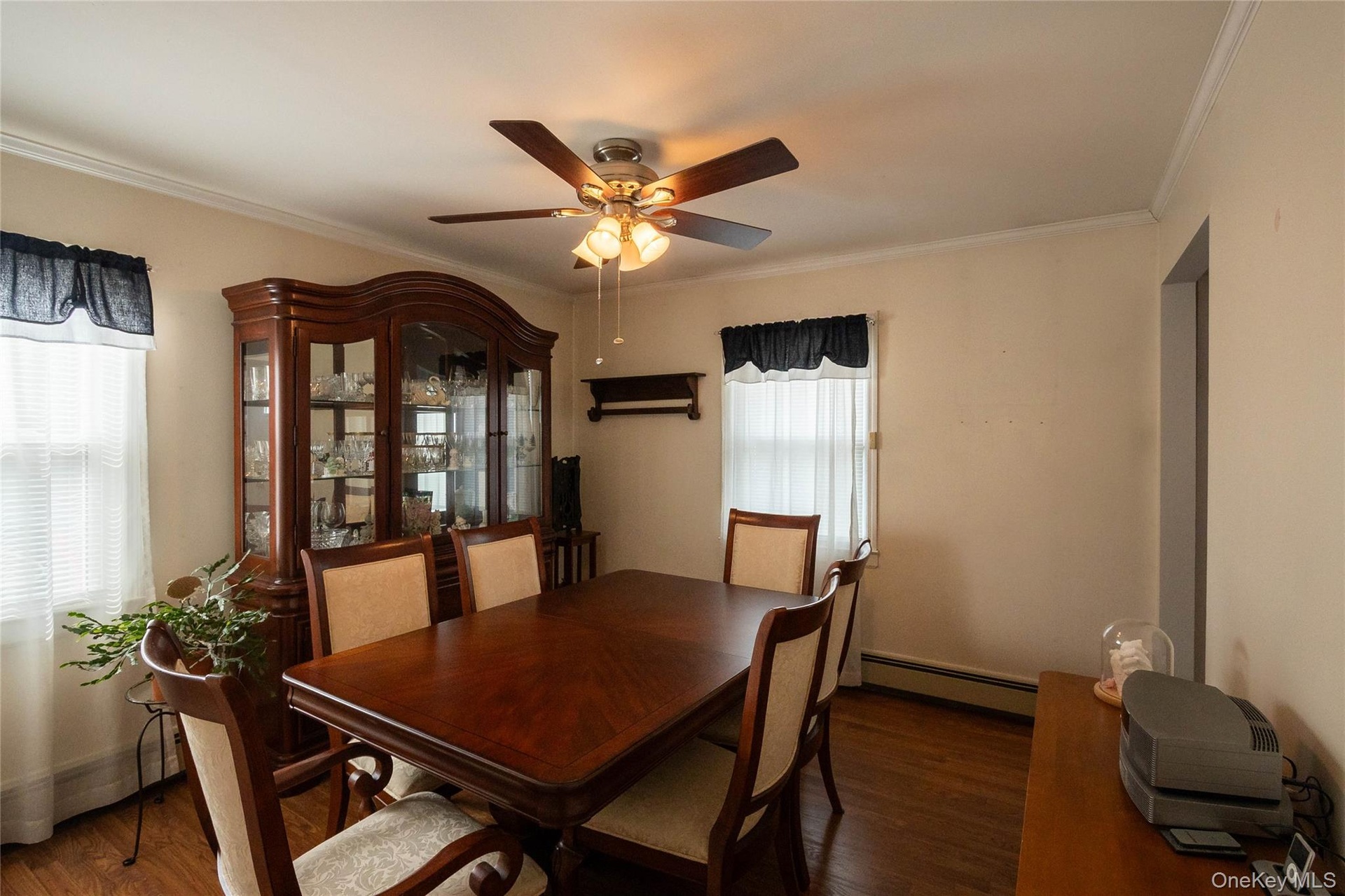 Wood-finish flooring, crown molding, ceiling fan, and window with blinds