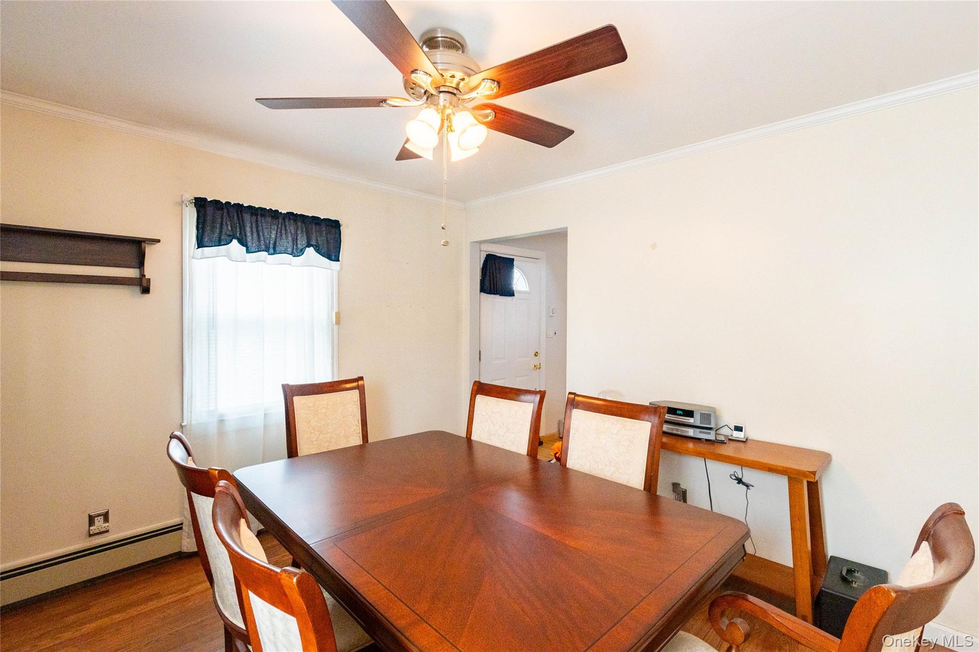 Ceiling fan with integrated lighting, wood-finish flooring, white trim, and a window for natural light