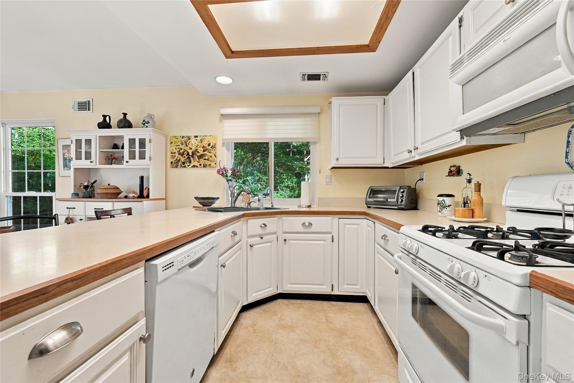 The Eat In Kitchen Offers Walls Of Cabinetry With Ample Storage, Oversized Kitchen Sink With A Large Window Above, Vast Counter/Serving Spaces & Opens