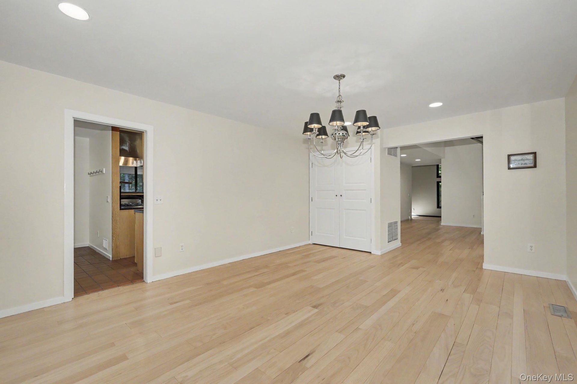 Light-filled formal dining room with a large picture window and direct access to the kitchen, ideal for entertaining.
