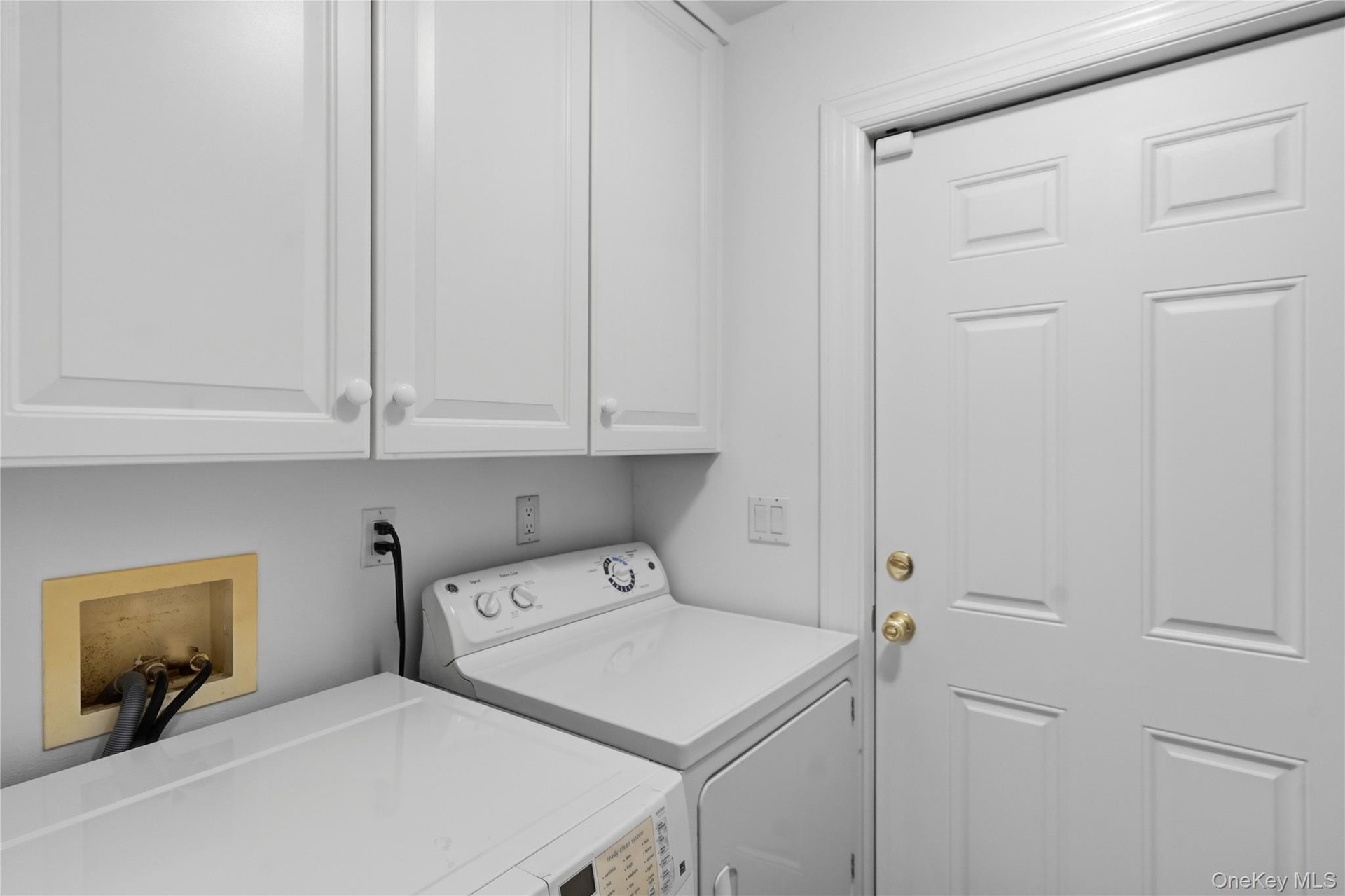 Laundry room with extensive shelving and side-yard access