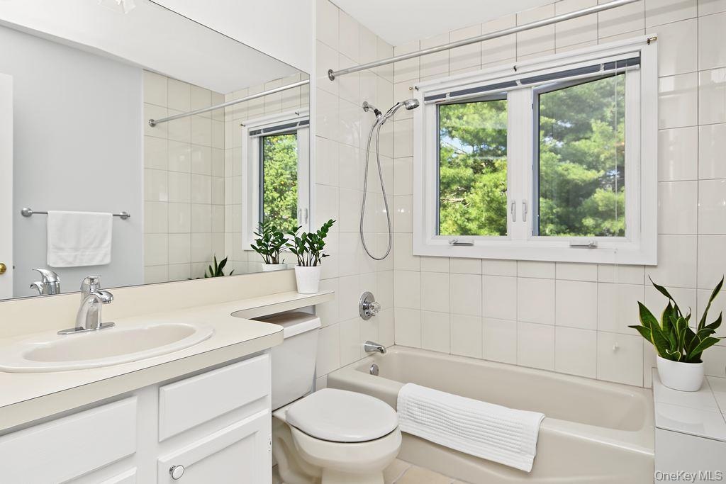 Bathroom has sink with vanity and bathtub with shower combo