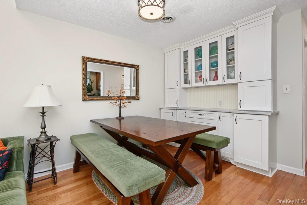 Dining room has hardwood floors and built in wall unit with marble top