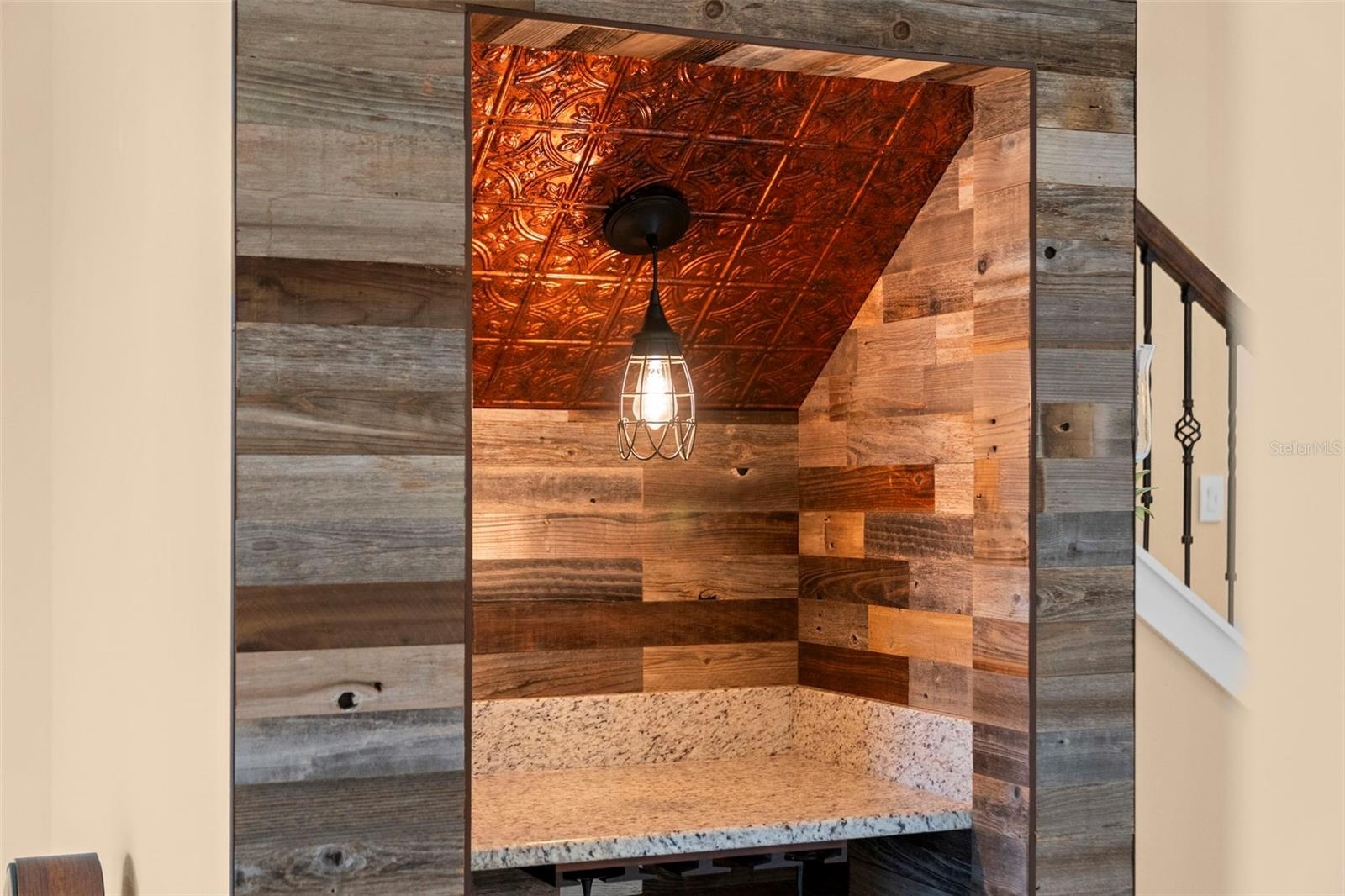 Wood accents, a decorative ceiling, and pendant lighting make this custom wine nook a conversation piece.