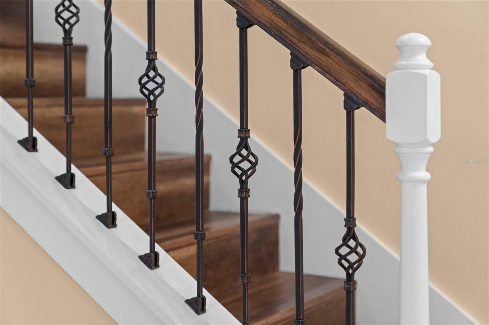 Rich wood tones and decorative ironwork add character to the staircase.