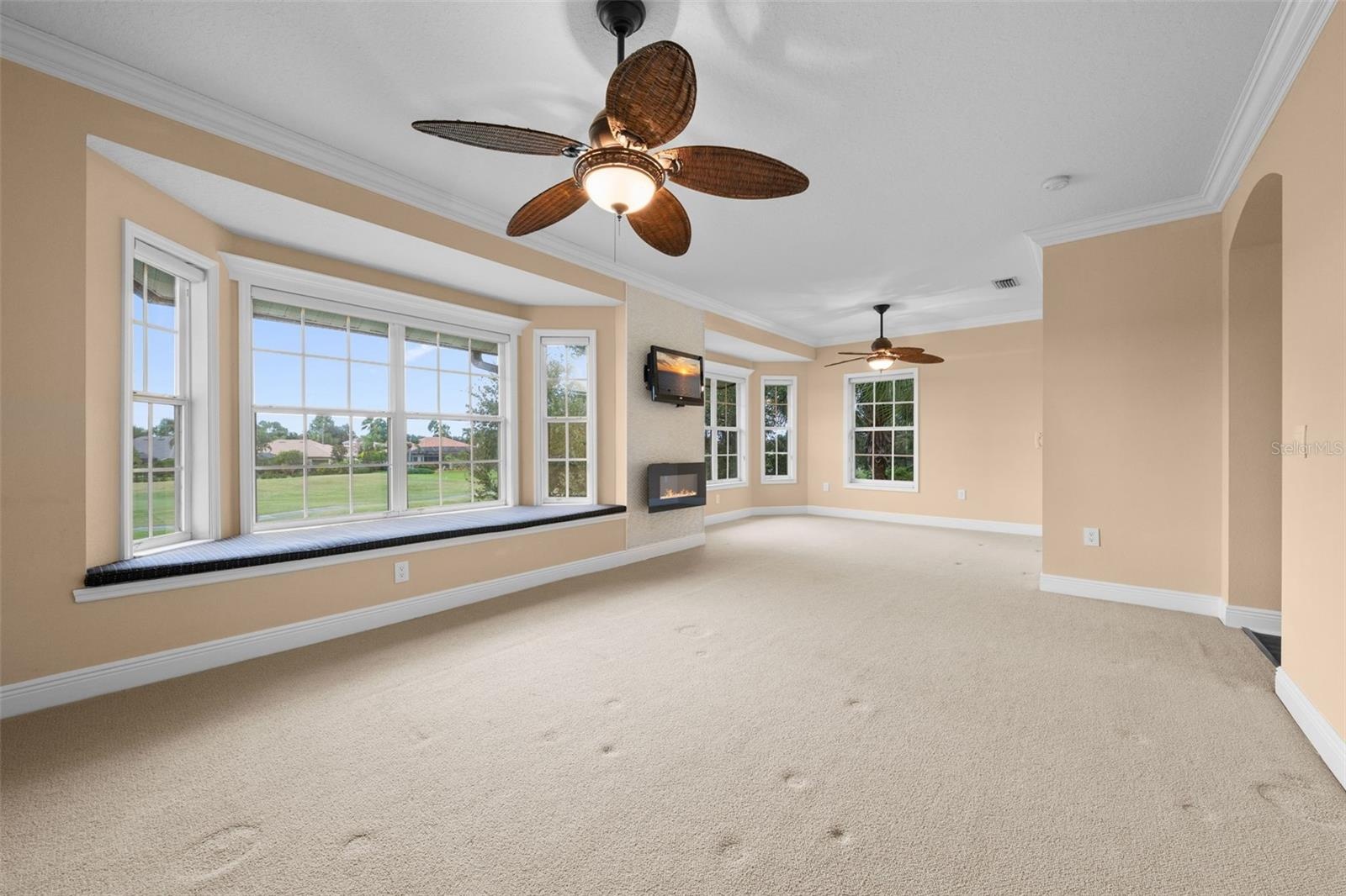 A spacious, light-filled retreat with expansive windows, a built-in window seat, and beautiful views.