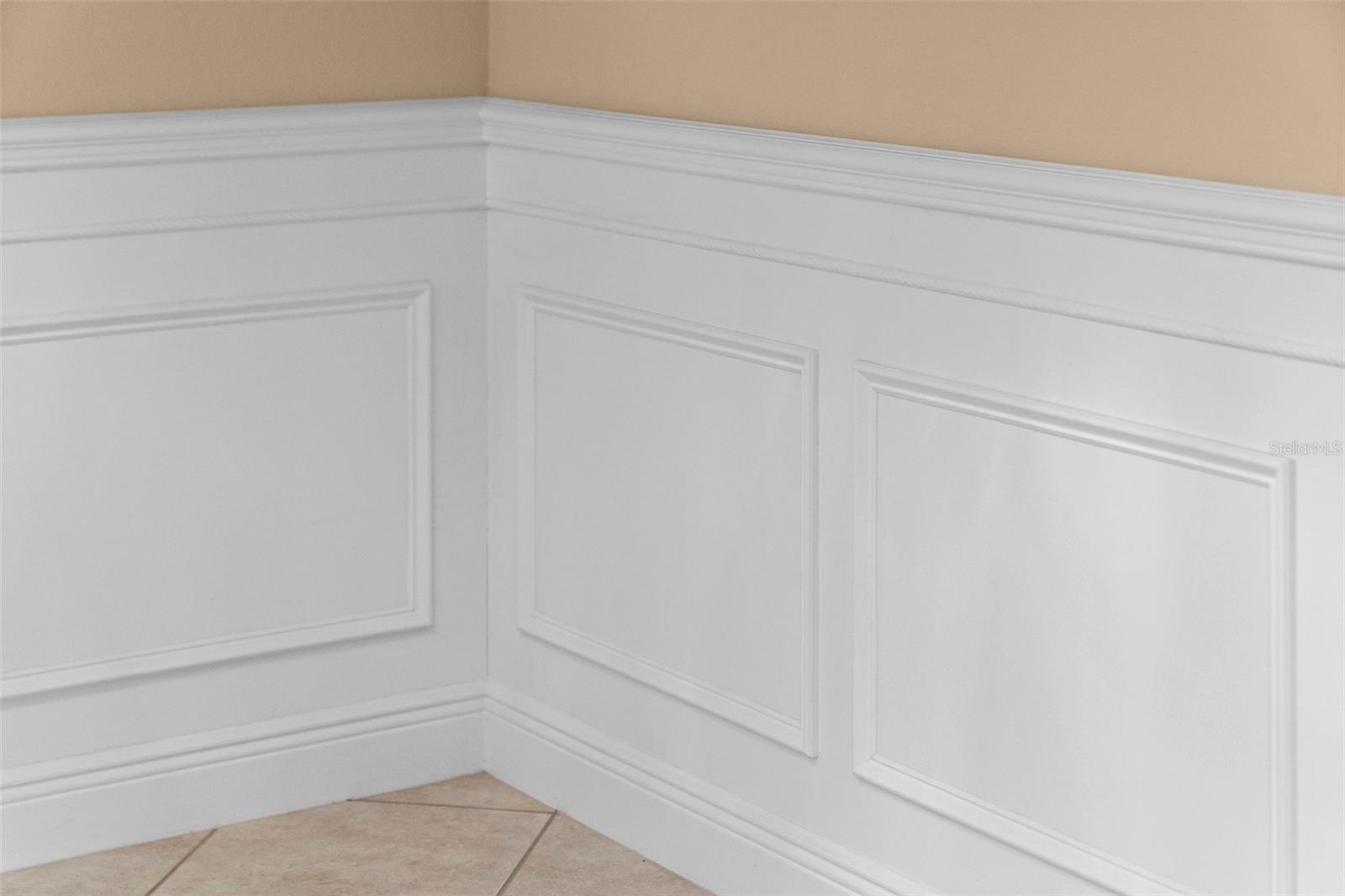 Detailed wainscoting adds timeless charm to the home’s gathering spaces.