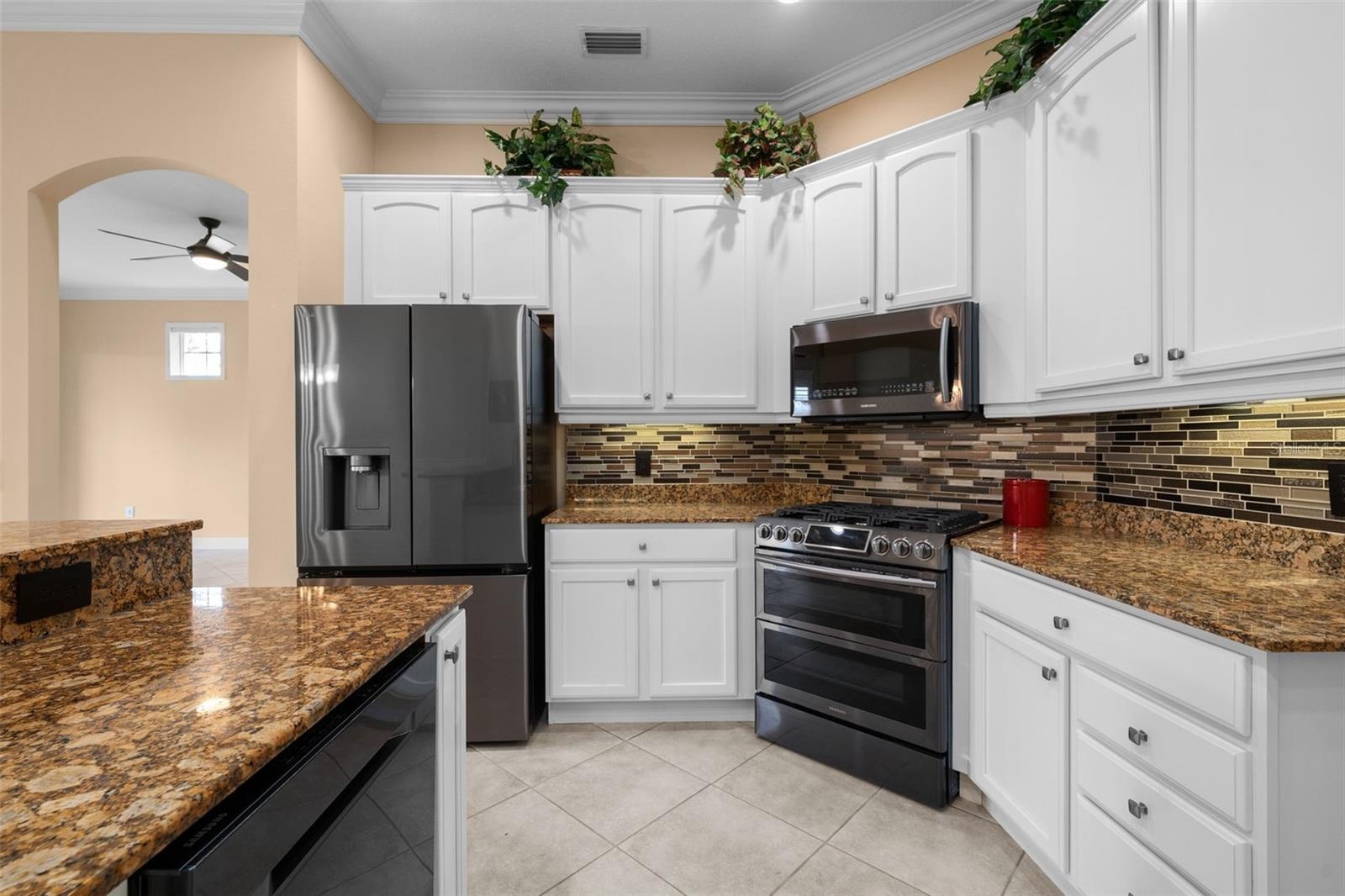 A gas range, decorative backsplash, and under-cabinet lighting bring style and function to meal prep.