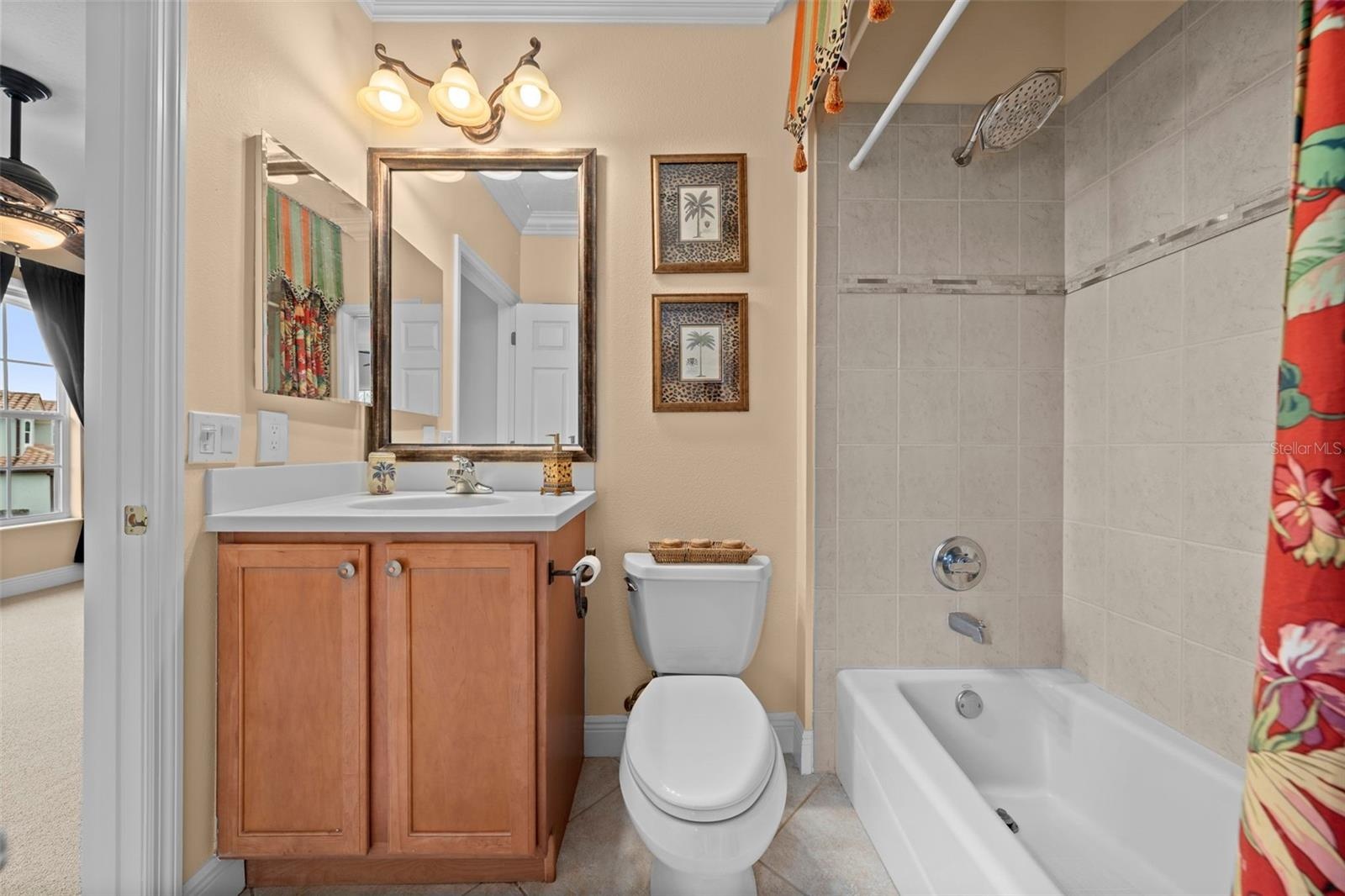 A conveniently arranged guest bath with a tub-and-shower combination and vanity storage.