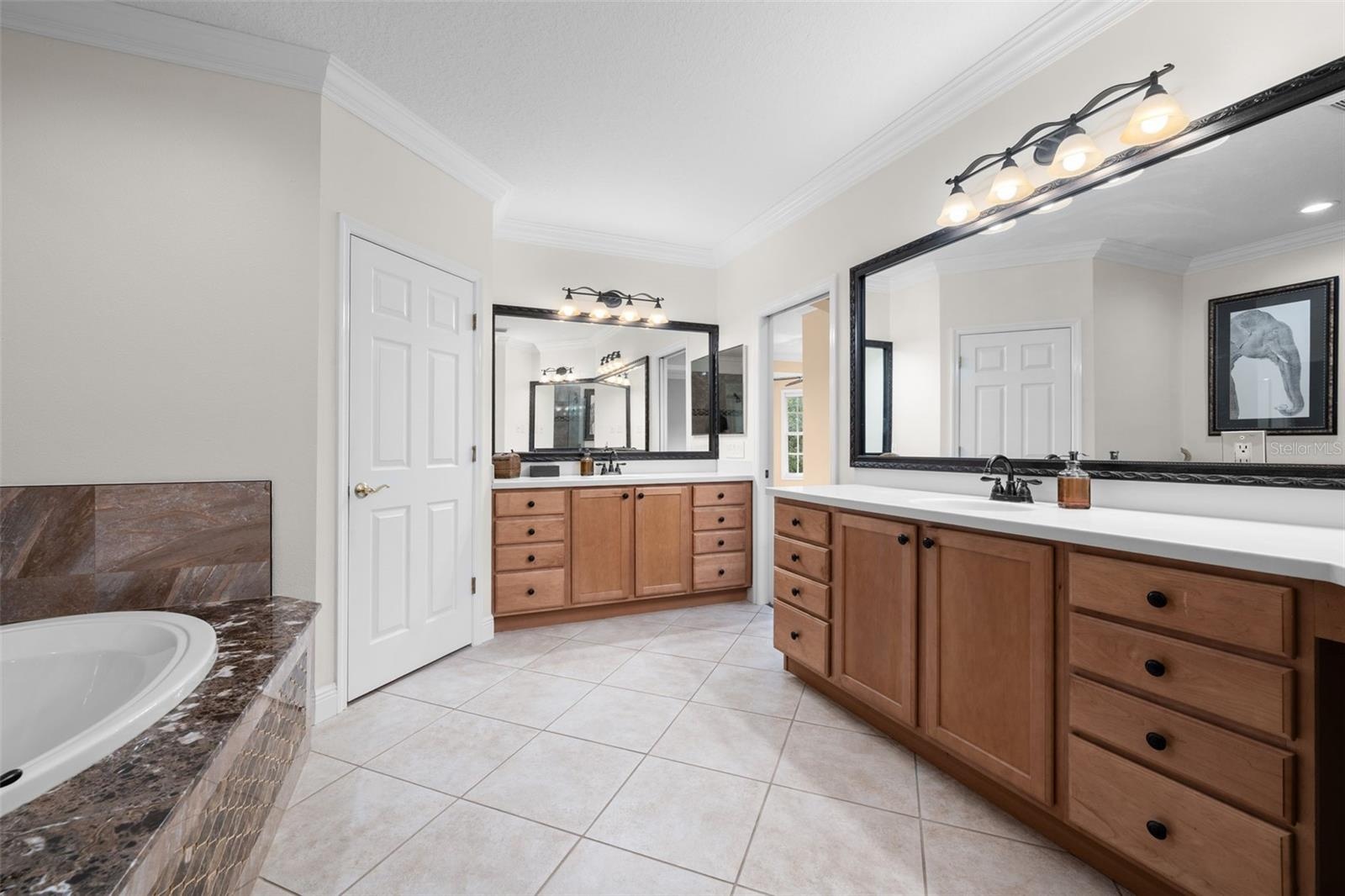 Separate vanities and abundant drawer space make sharing the primary bath easy.