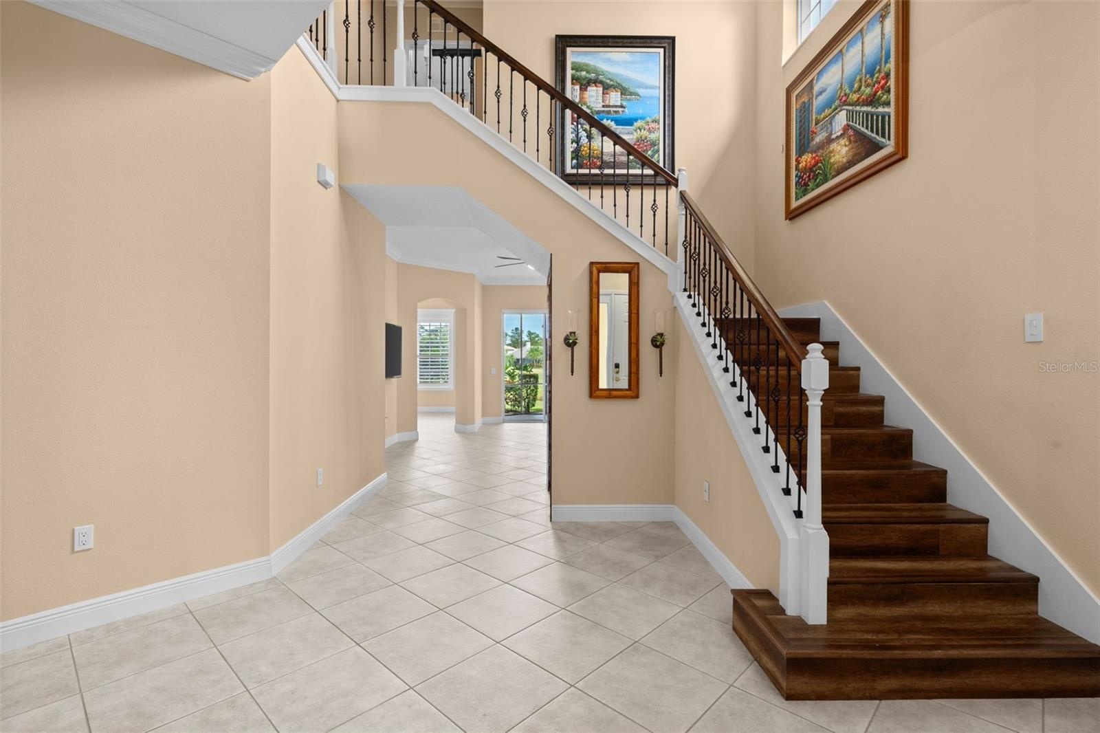 Soaring ceilings and a wood staircase with wrought iron accents make a memorable first impression.