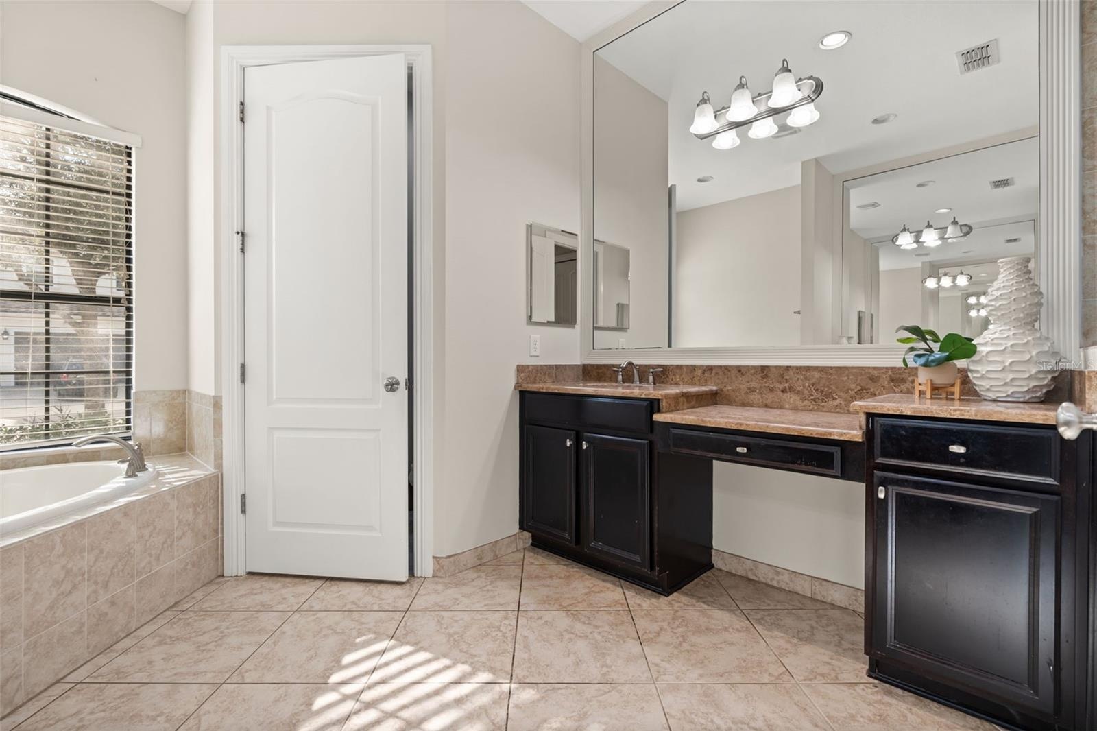 Downstairs Primary bathroom. 2 separate vanities, soaking tub, private wash closet and walk in shower