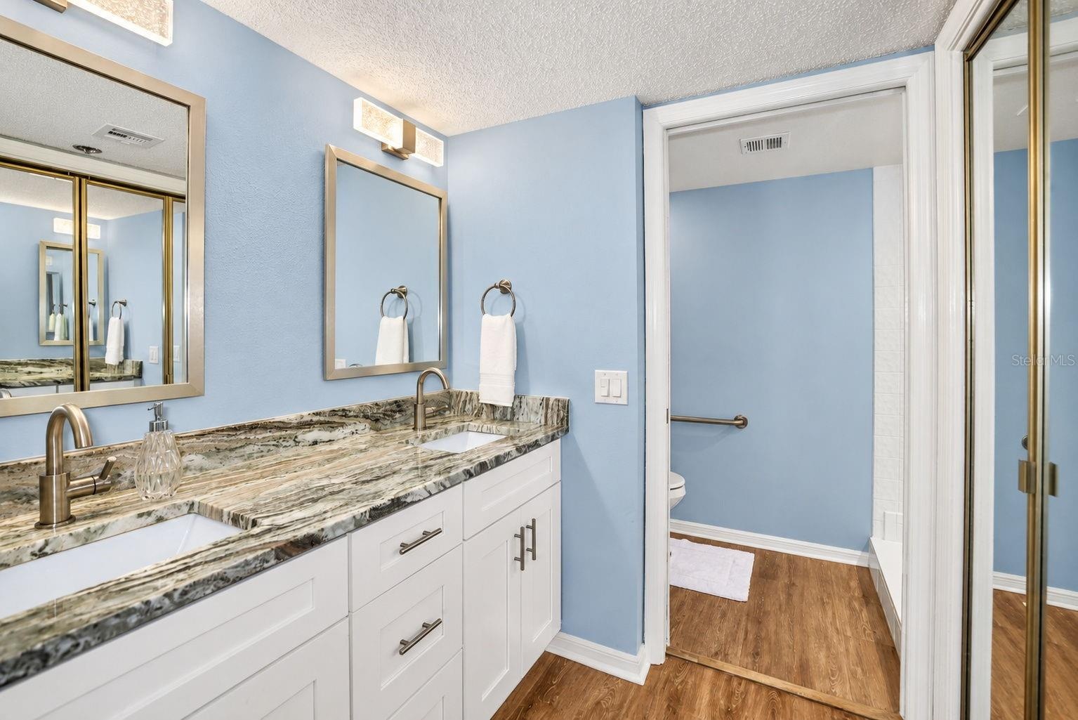 Primary Bathroom, newly updated with double sink shaker cabinet vanity with soft close drawers, lighting, mirrors and paint.