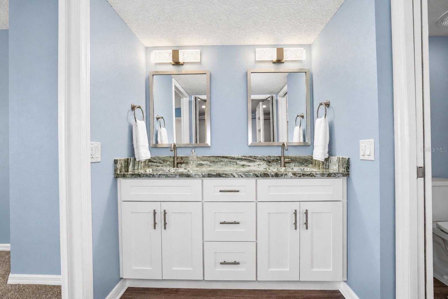 Primary Bathroom, newly updated with double sink shaker cabinet vanity with soft close drawers, lighting, mirrors and paint.