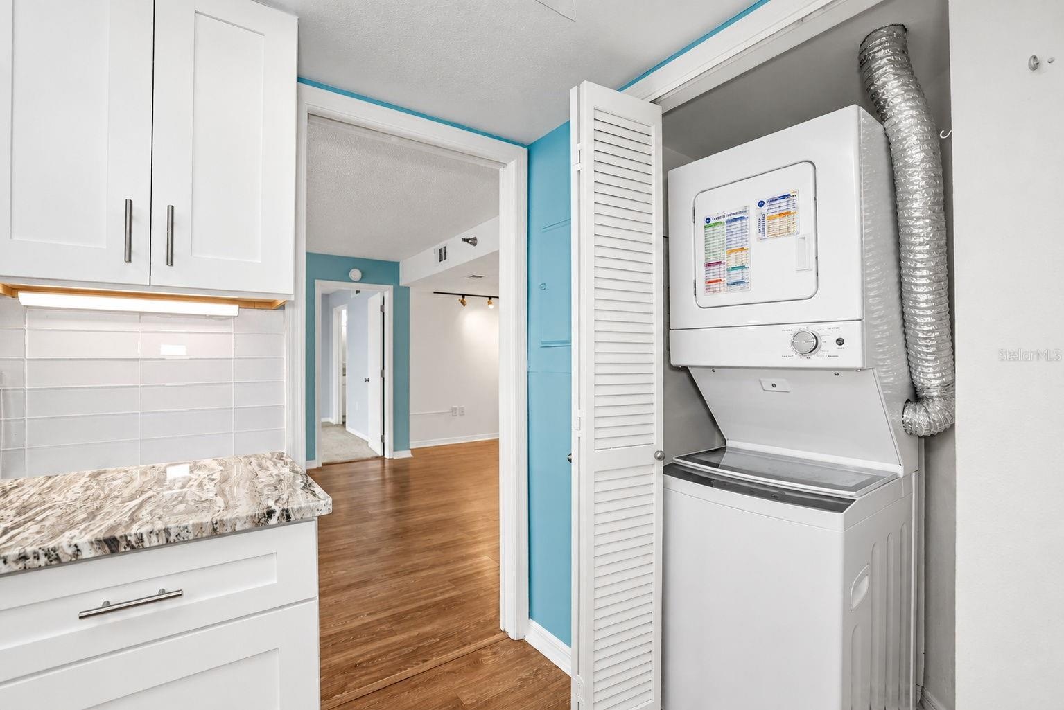 Notice pretty glass subway tiles and Washer Dryer conveniently located in the unit