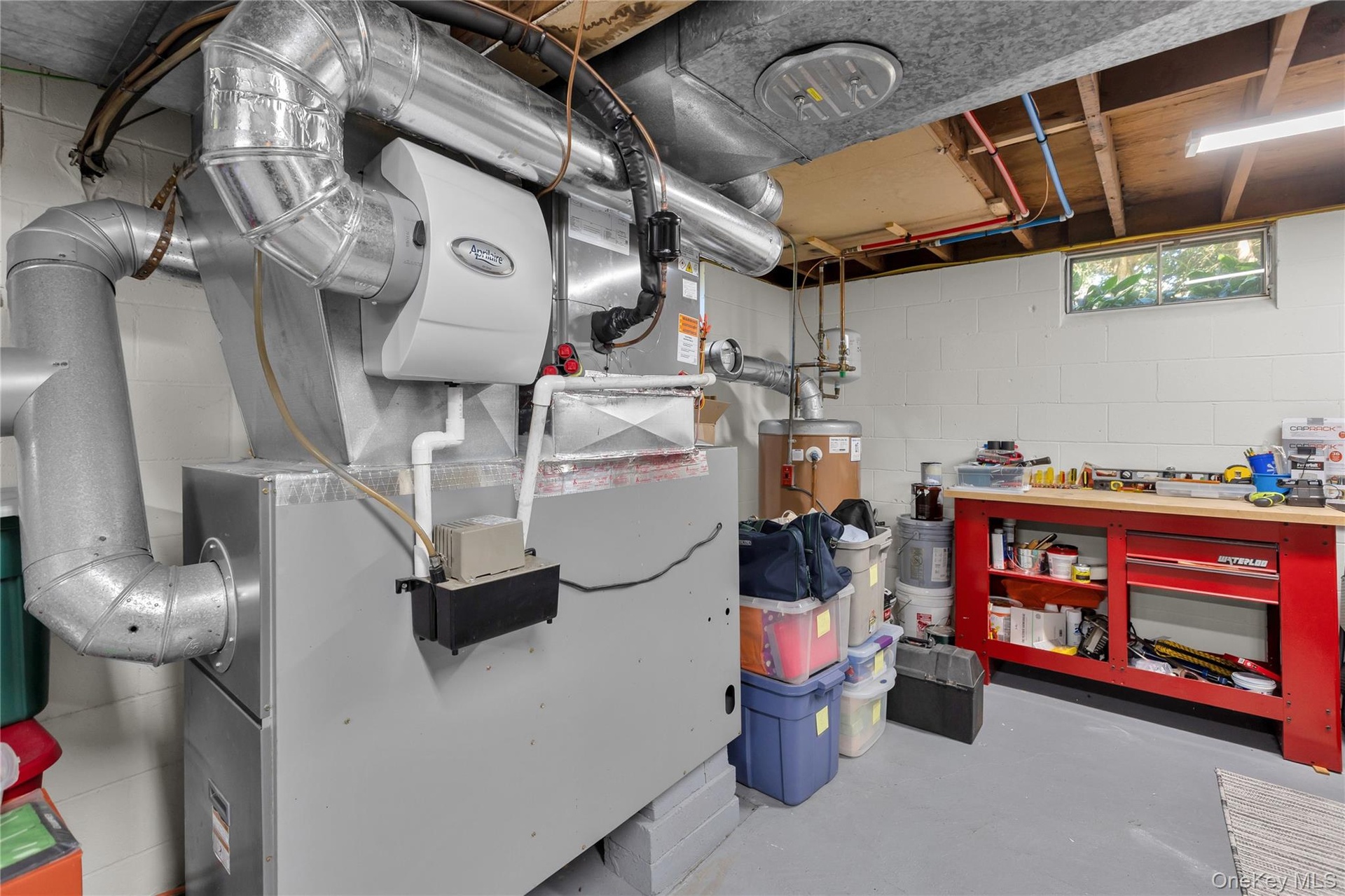 HVAC system with attached humidifier, water heater, and a workbench with storage