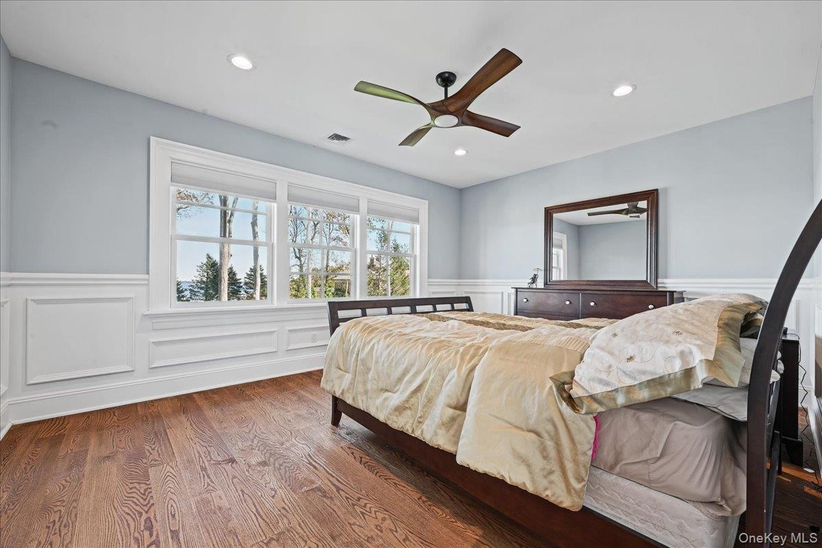 Wood-finish flooring, wainscoting, recessed lighting, ceiling fan, and large windows