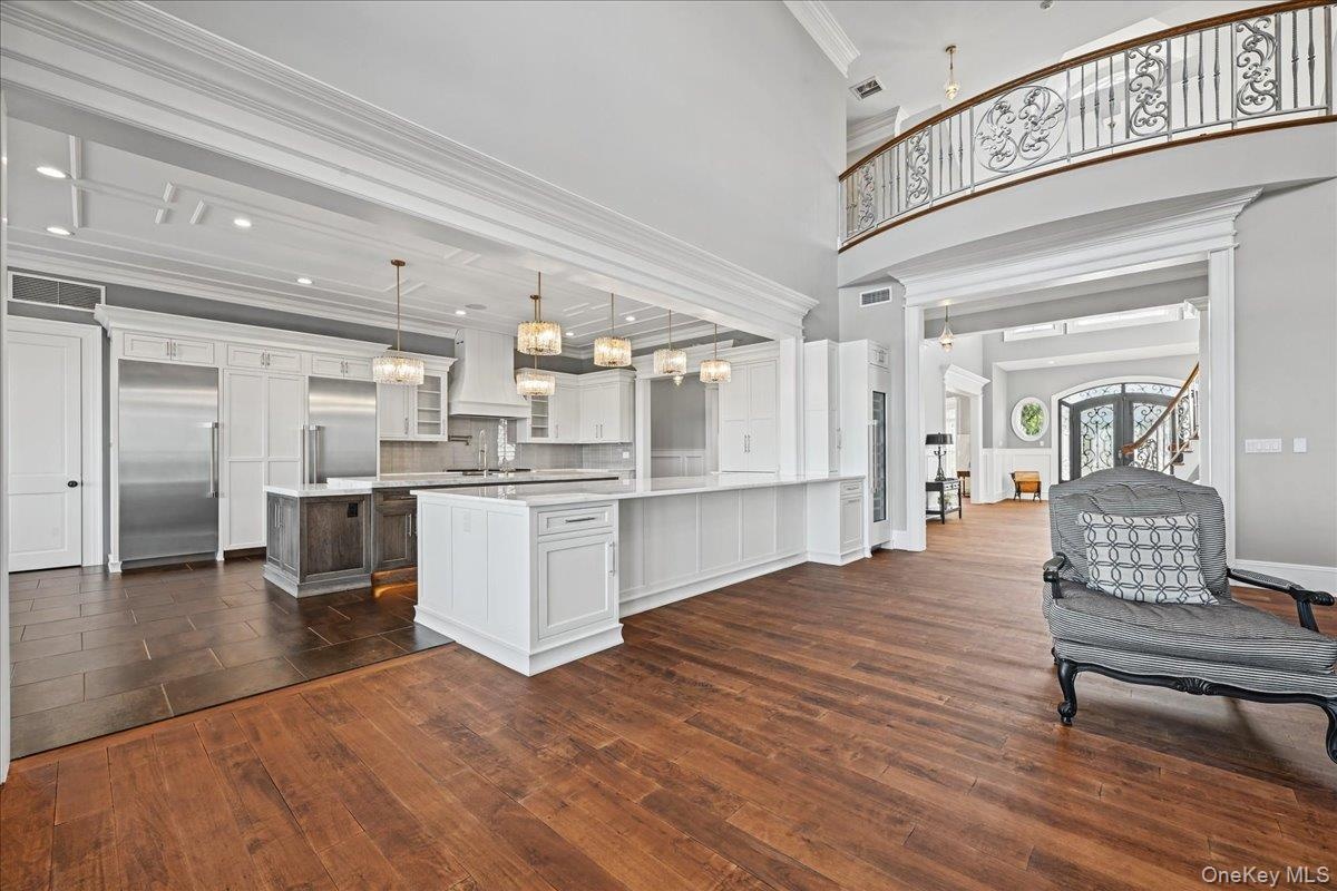 Expansive hardwood-finish flooring with a grand two-story ceiling
