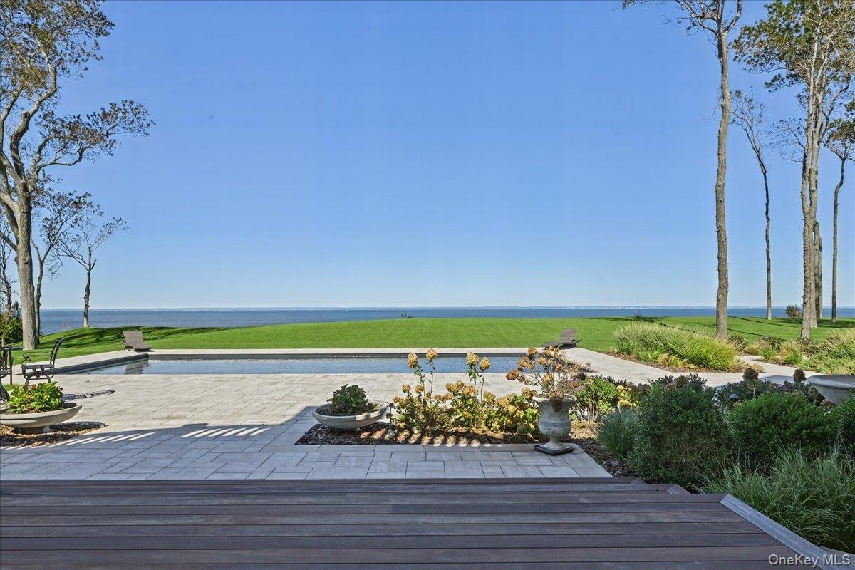 Expansive exterior with a rectangular swimming pool, surrounding paver patio, and wood-finish decking