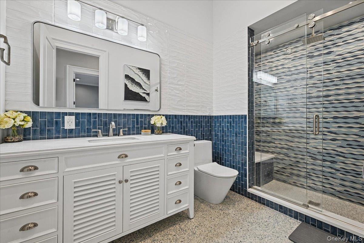 White double vanity with a rectangular undermount sink, brushed nickel faucet, and cup pulls