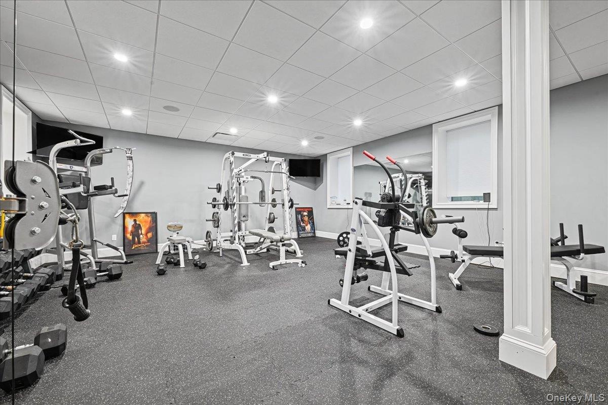 Dedicated fitness room featuring recessed lighting, a drop ceiling, and durable rubber flooring