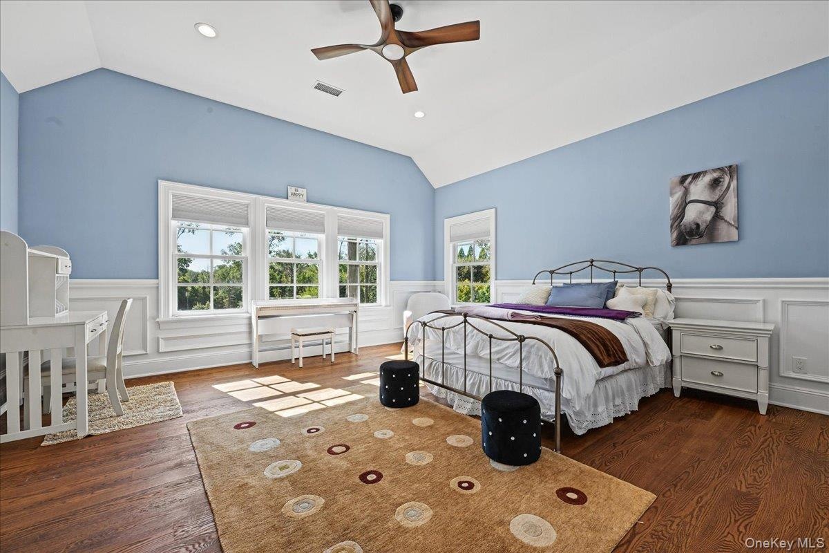 Vaulted ceiling with a wood-finish ceiling fan, recessed lighting, and rich wood-finish flooring