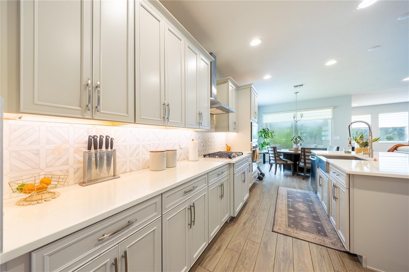 efined kitchen with expansive countertops, ample cabinetry, and a gas cooktop.