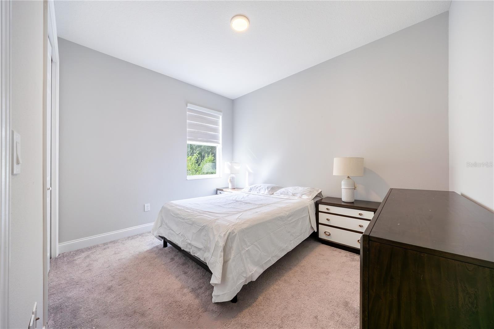 Comfortable bedroom with soft carpeting and a soothing neutral palette.