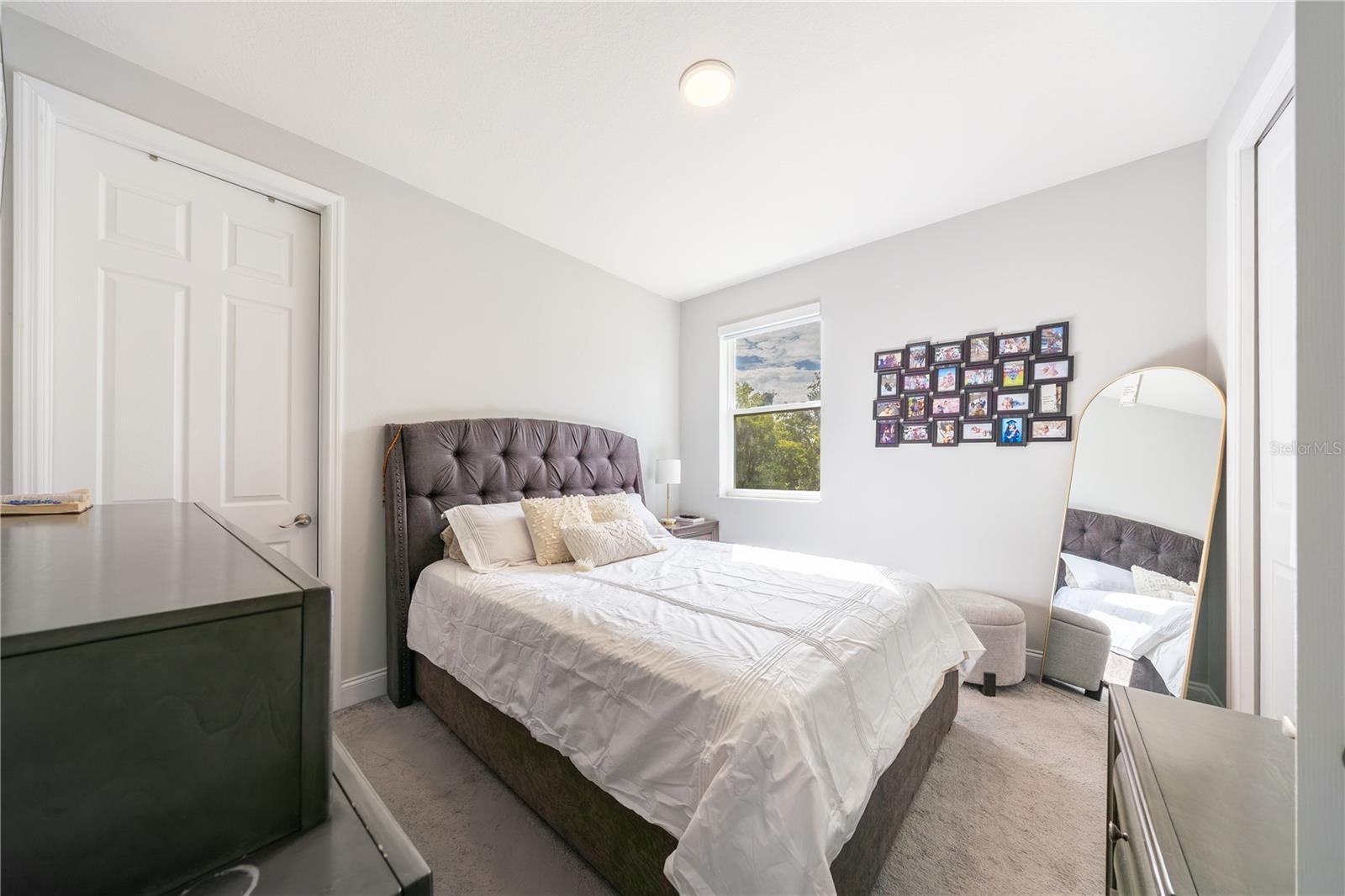 Inviting bedroom with soft carpeting, neutral tones, and a double-door closet.