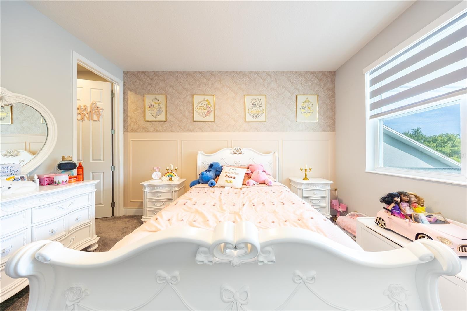 Charming bedroom with decorative wall paneling, patterned wallpaper, and a large window.