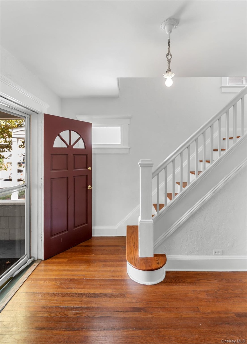 stairway to upstairs opposite front door with hardwood floors