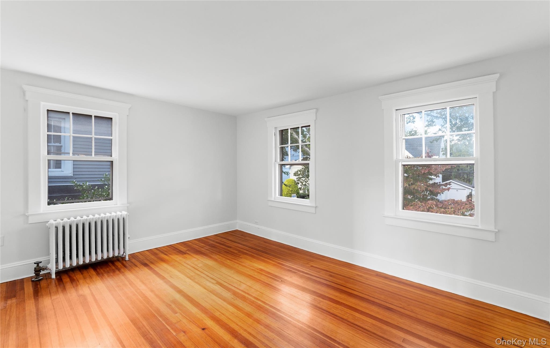 2 of 3 bedrooms with hardwood floors, radiator