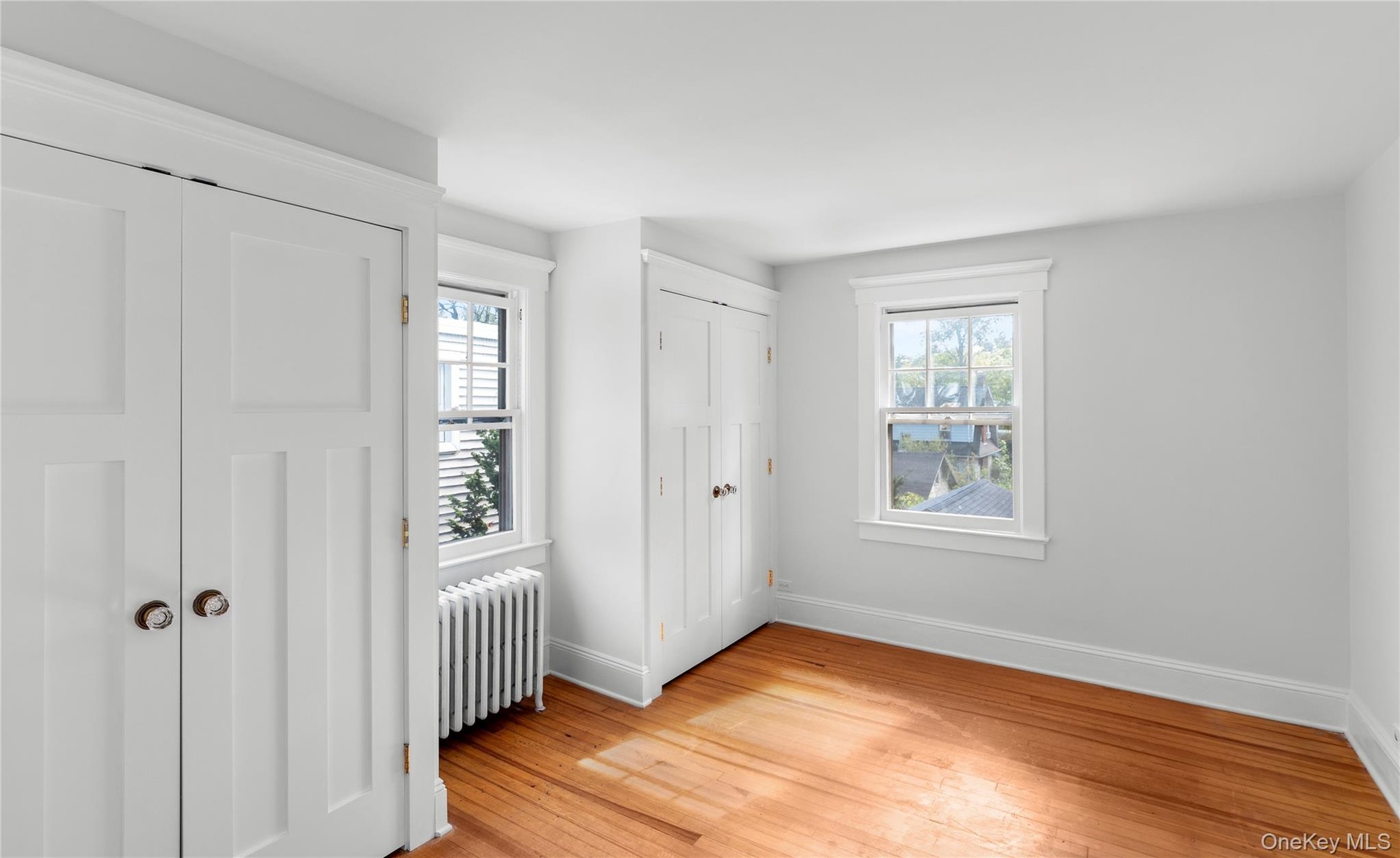 1 of 3 bedrooms with two closets and hardwood floors