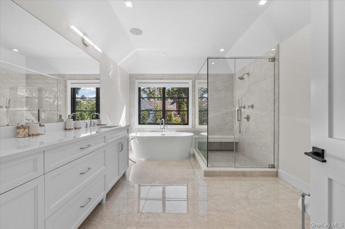 Luxurious primary bathroom with soaking tub, large, walk-in shower and double sink vanity.