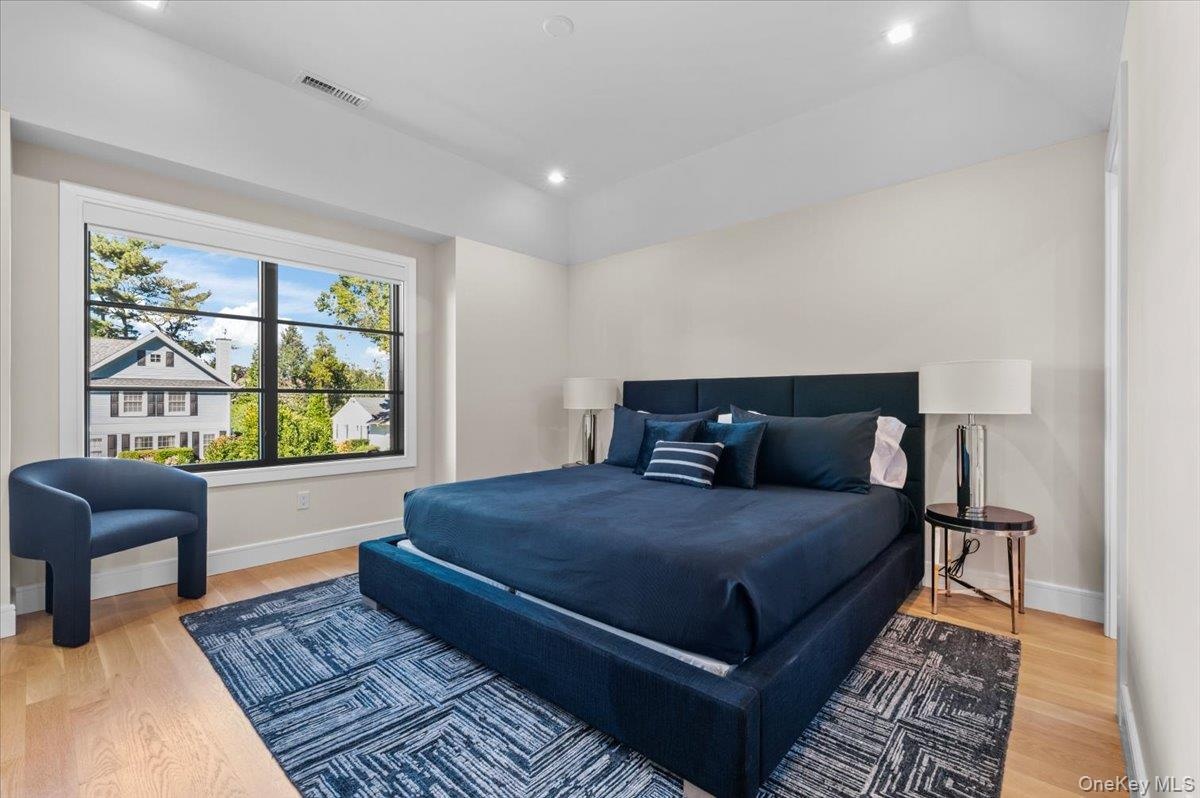 Hardwood flooring, recessed lighting, and a large window with dark trim