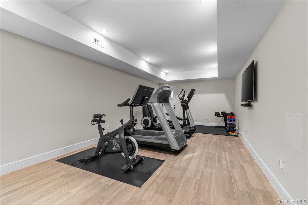 Recessed lighting, wood-finish flooring, and a mounted television
