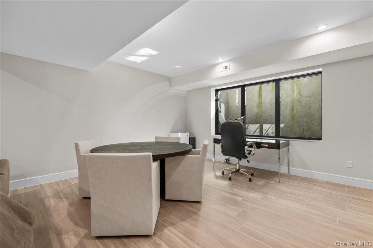Recessed lighting, light wood-finish flooring, and a large window