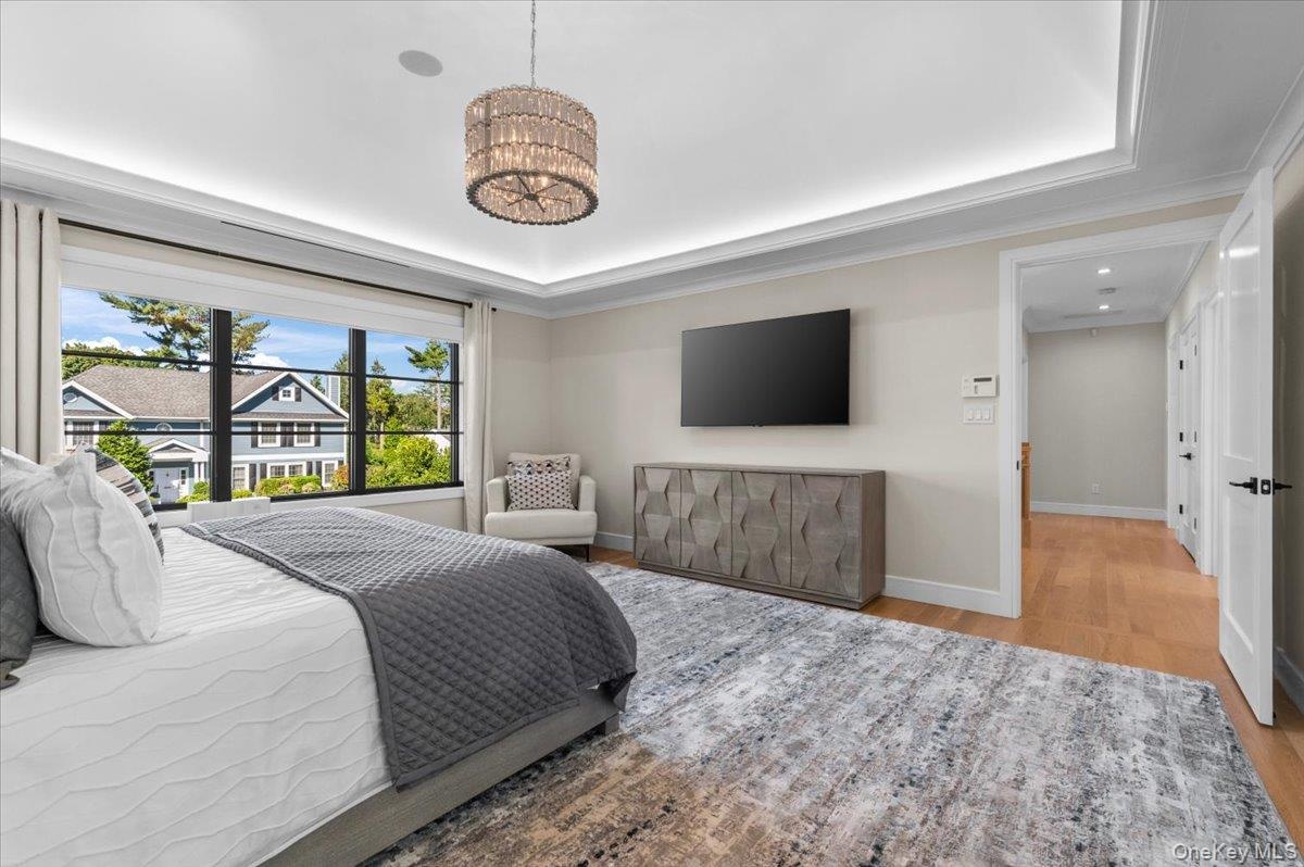 Recessed lighting, crown molding, wood-finish flooring, and a large window