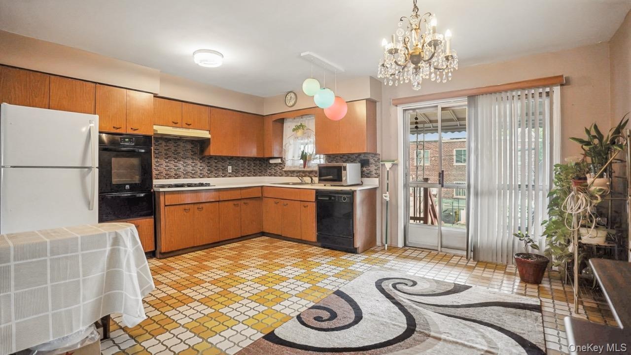 Kitchen featuring wood-finish cabinetry, tile flooring, built-in oven, and a sliding glass door