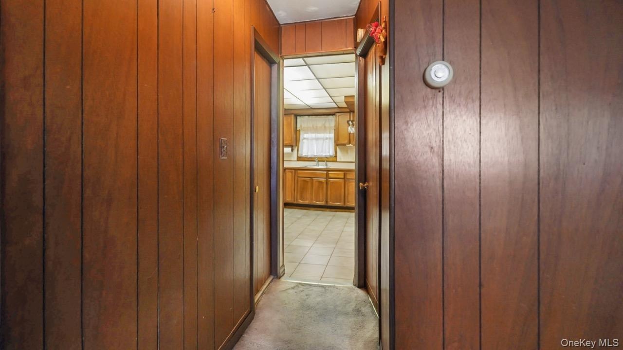 Wood paneling and carpeted flooring in hallway