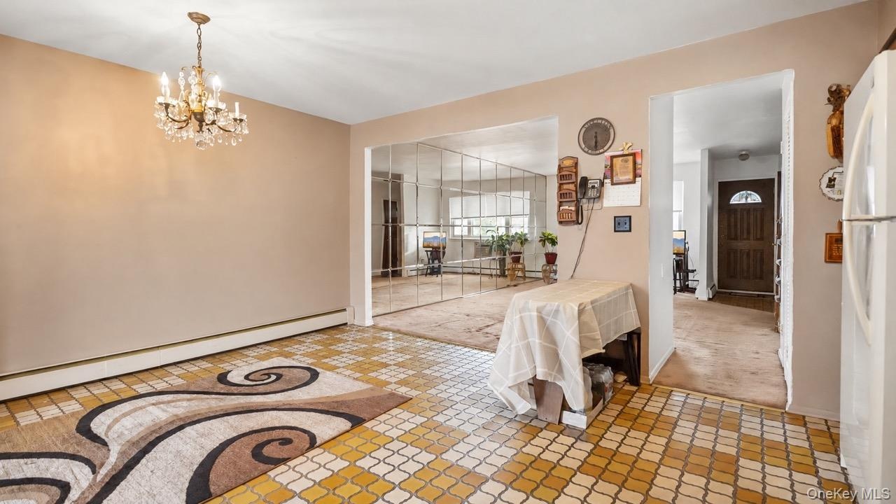 Recessed mirror wall paneling, crystal chandelier, and patterned floor tile
