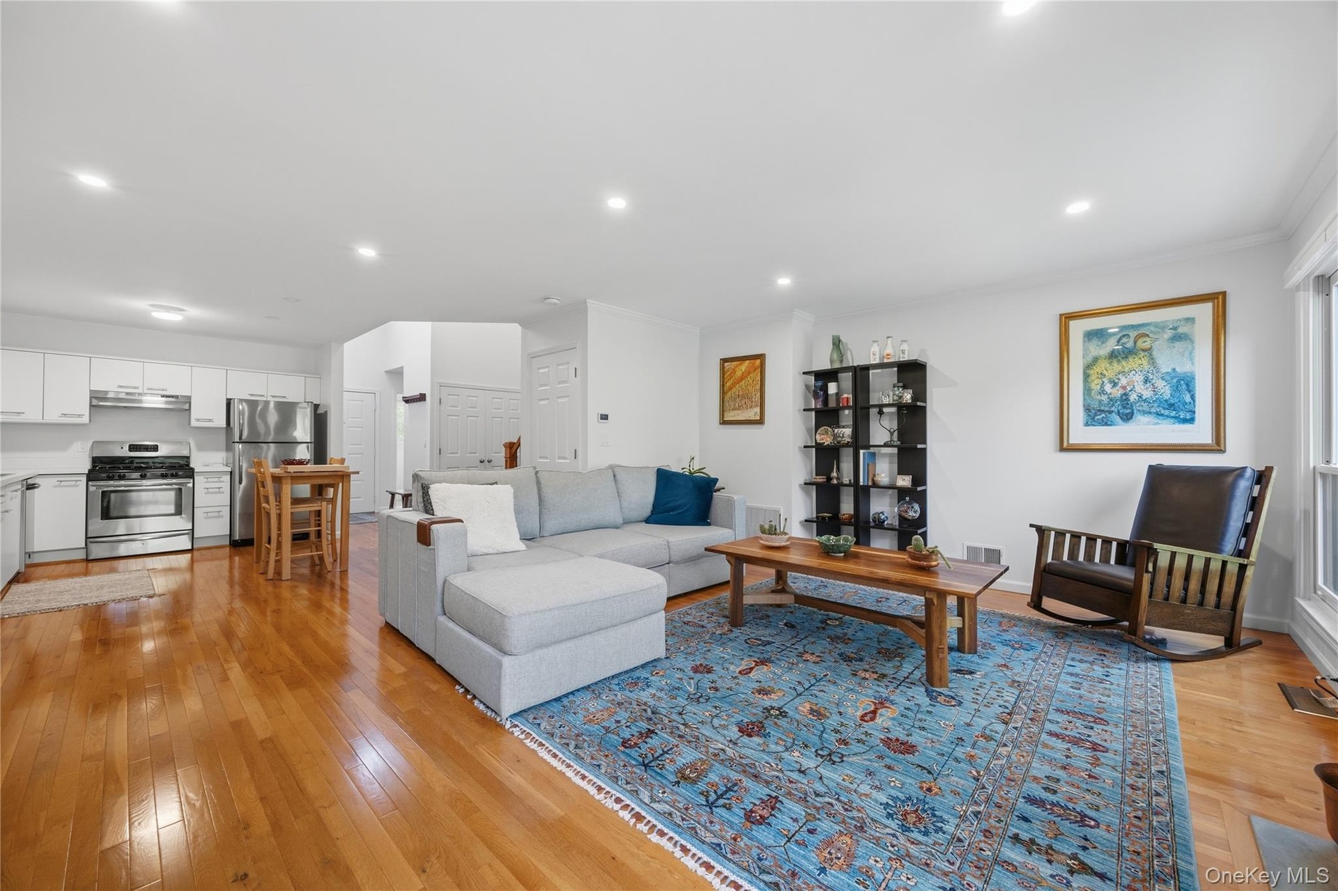 View of Living Room with Kitchen beyond; recessed lights & hardwood floors