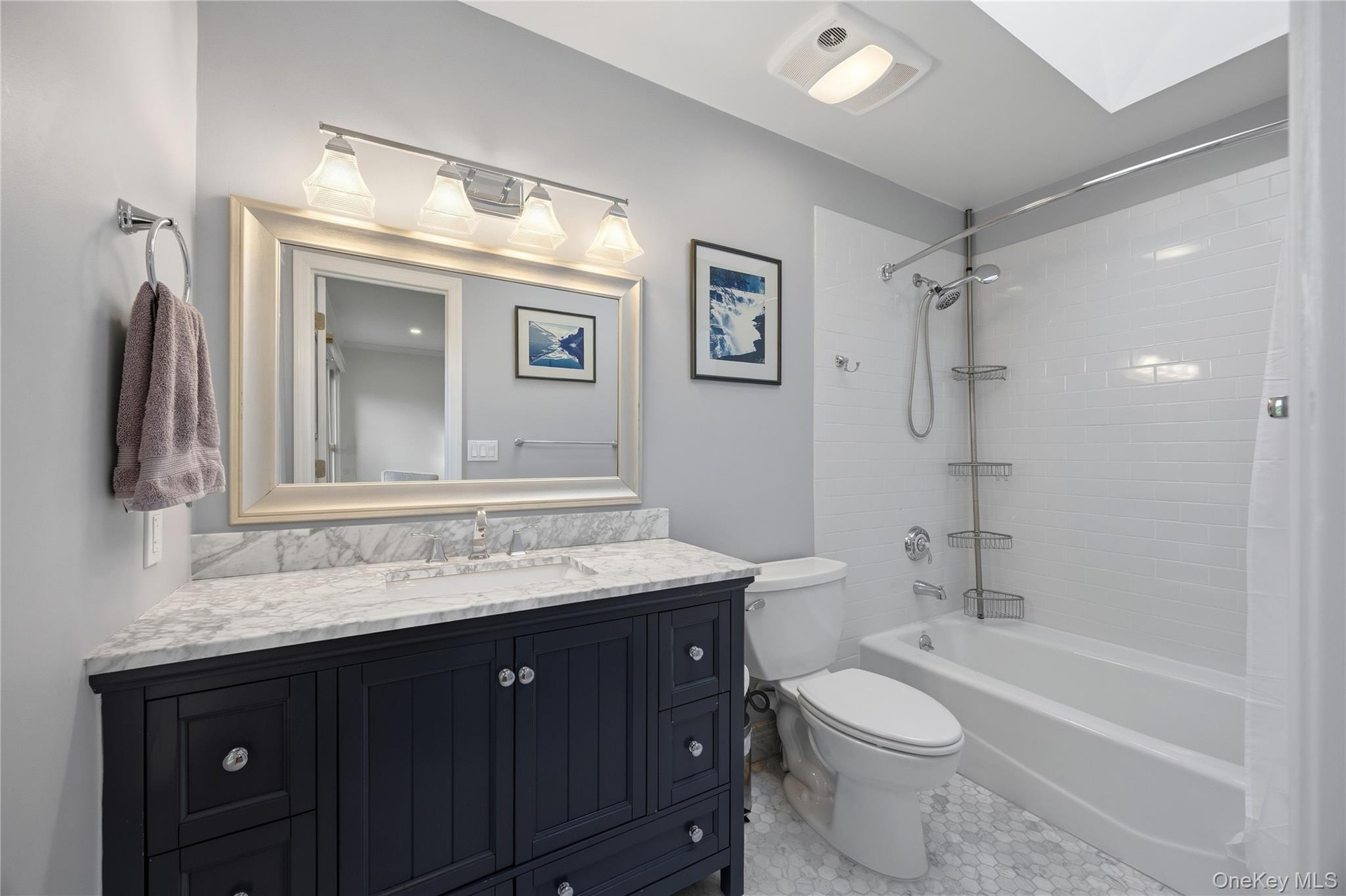 Updated Primary Bathroom (2020) with marble vanity & floor, bathtub and skylight