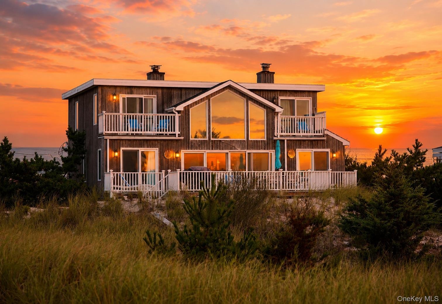 Two-story residence featuring wood siding and multiple balconies with white railings